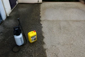 Terrasse en béton nettoyée au J-Net Gros Travaux avec pulvérisateur et bidon posés au sol